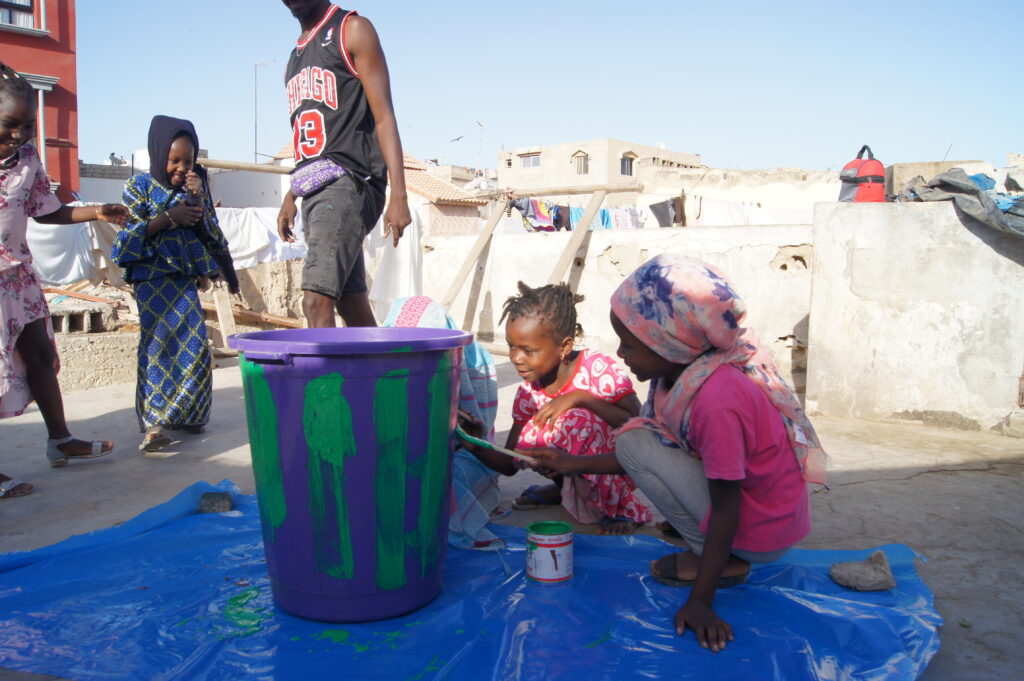 enfants qui peignent une poubelle